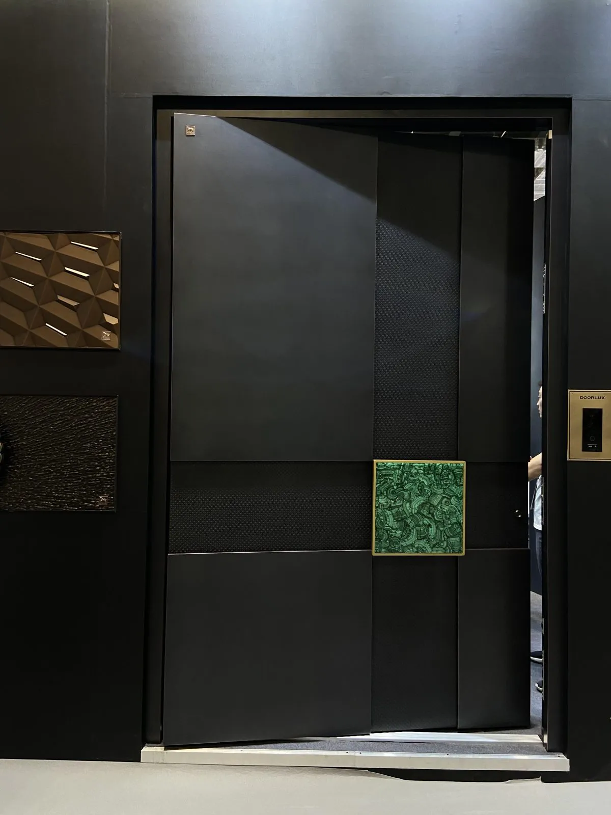 Matte black panels with a square green stone-pattern pull.