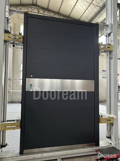 Black pivot door with a steel band, photographed on our floor