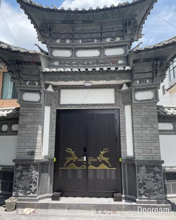 Dark-brown double door with gold leaping-deer and mountain inlay, in a traditional gateway, installed at a client's home