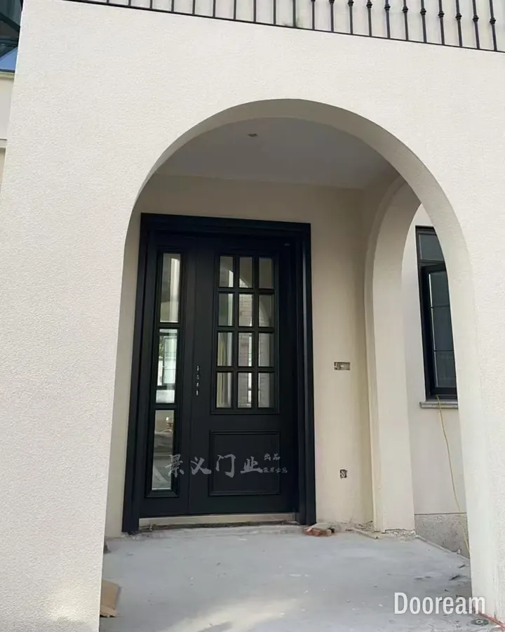 Black single door with a glazed grid panel and sidelight under an arched porch, installed at a client's home