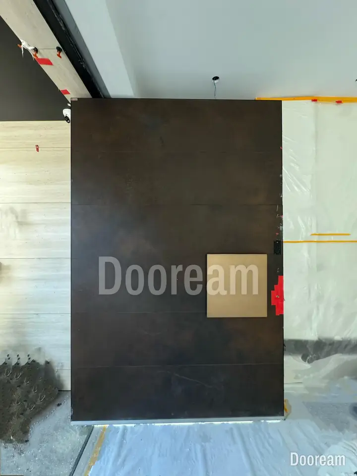 Dark entrance door with a square gold accent, installed