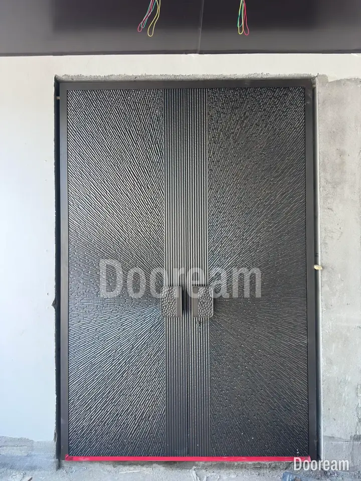 Dark double door with a radiating texture and square relief handles, installed