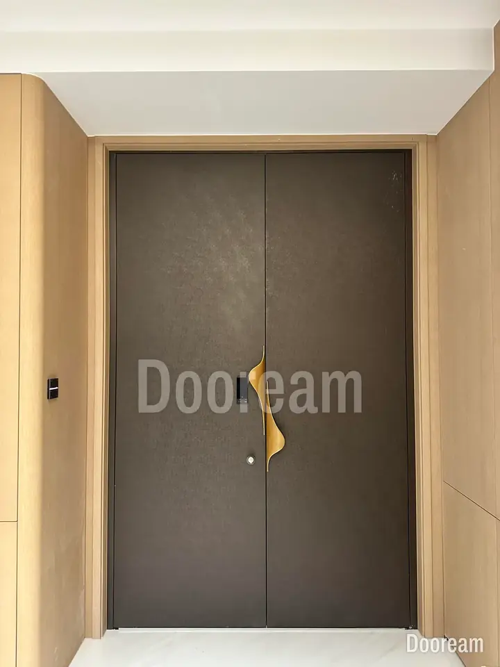 Grey-brown textured double door with gold ribbon handles, installed