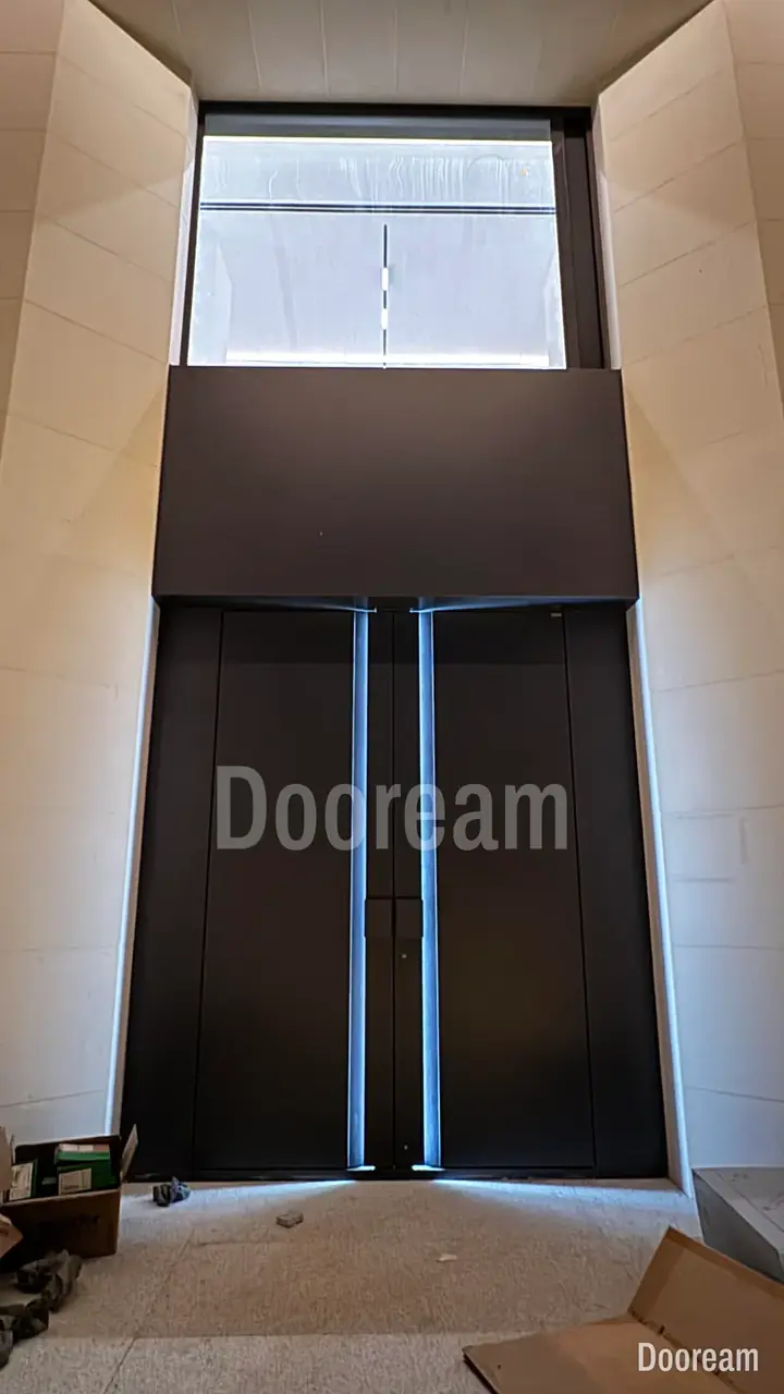 Dark minimalist double door in a double-height entrance, installed