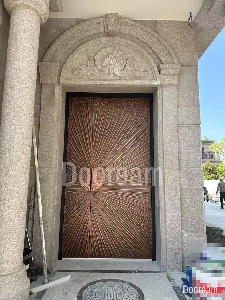 Copper sunburst door with a round centre handle, installed