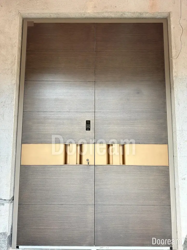 Grey double door with a horizontal texture and a wide gold band, installed