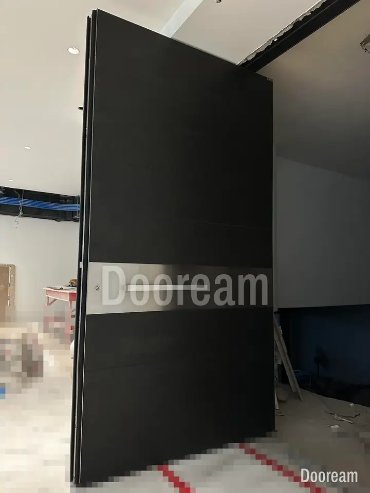 Black entrance door with a silver band, on site during the build, installed
