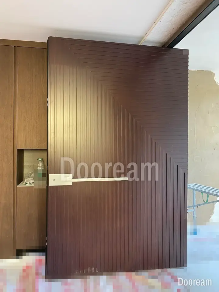 Brown entrance door with close vertical fluting and a long, slim horizontal handle, installed