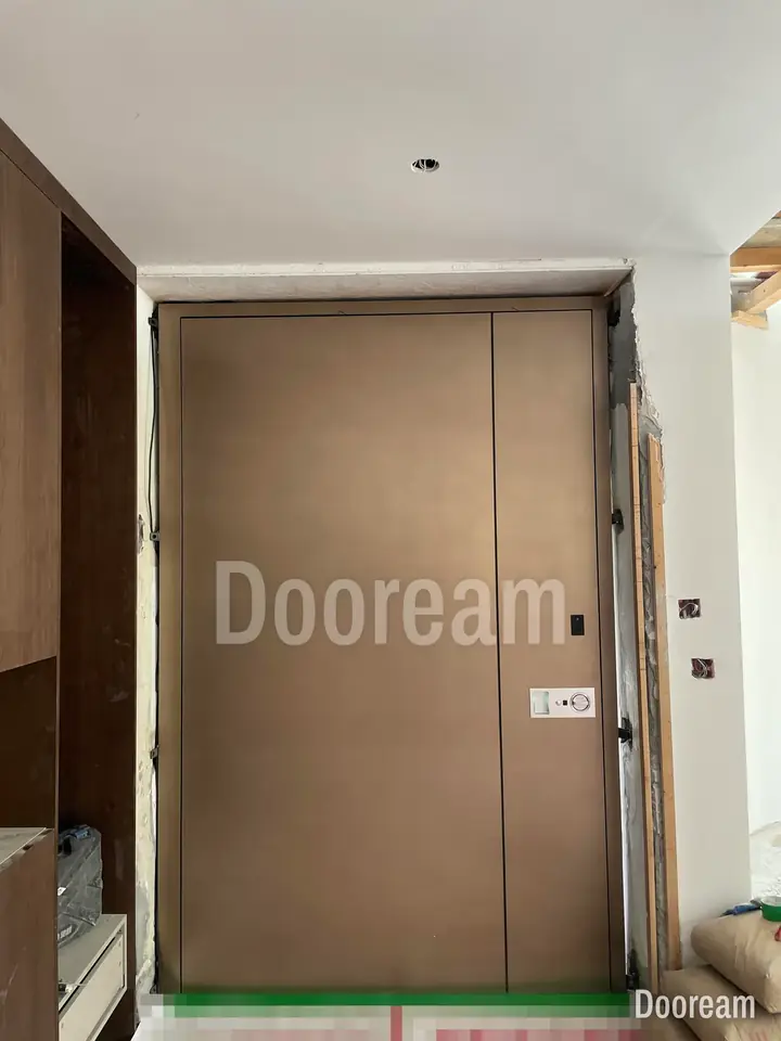 Light-bronze unequal double door with a narrow vertical joint, installed