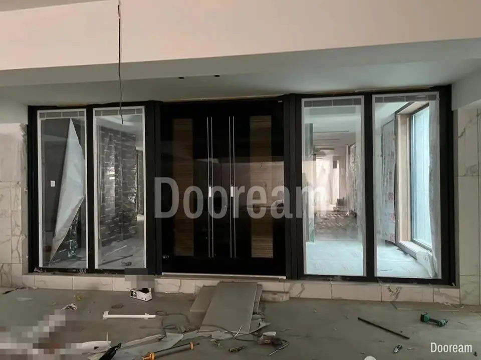 Dark double door with long vertical handles, between glass panels, installed