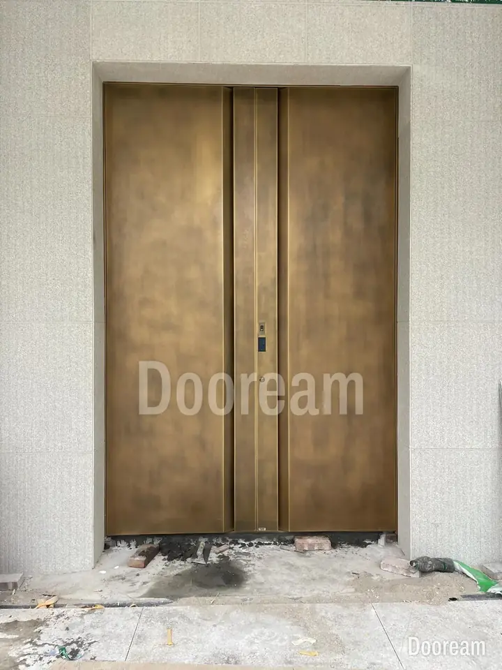 Antique-bronze double door with long handles in a diagonal-line pattern, installed